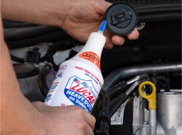 person adding Lucas Oil Stabilizer