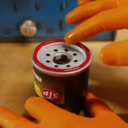 person lubricating the rubber ring at the top of the STP air filter