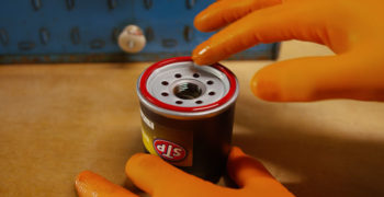 person lubricating the rubber ring at the top of the STP air filter