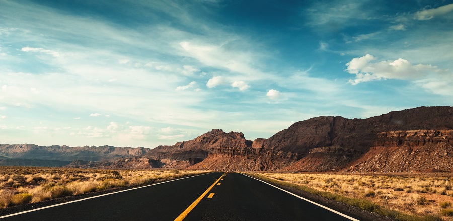 Highway road leading towards mountains outside of Moab.
