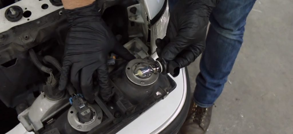Removing a headlight bulb from a headlight casing placed on the fascia