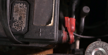positive battery plus sign on old side post battery showing corrosion to terminal