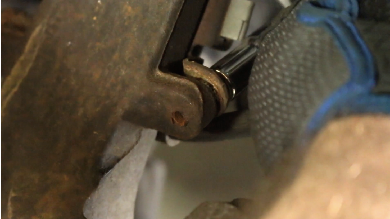 Person using a ratchet to remove the brake line from a Chevy Trailblazer
