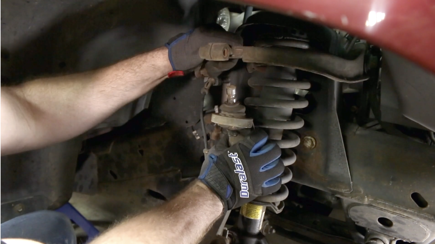 Person separating spindle from upper control arm