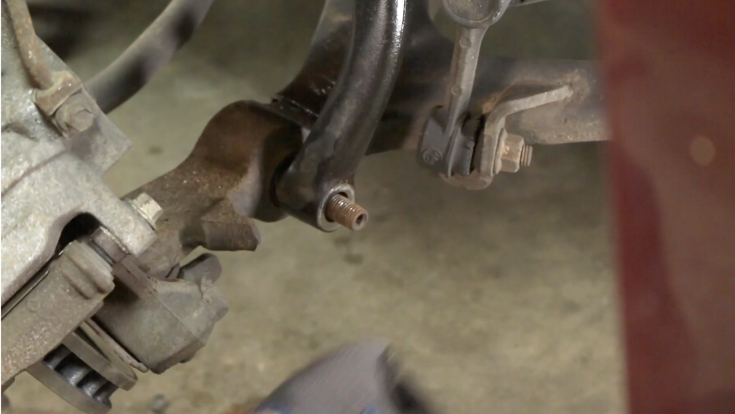 Person removing the lower bracket mounting nut