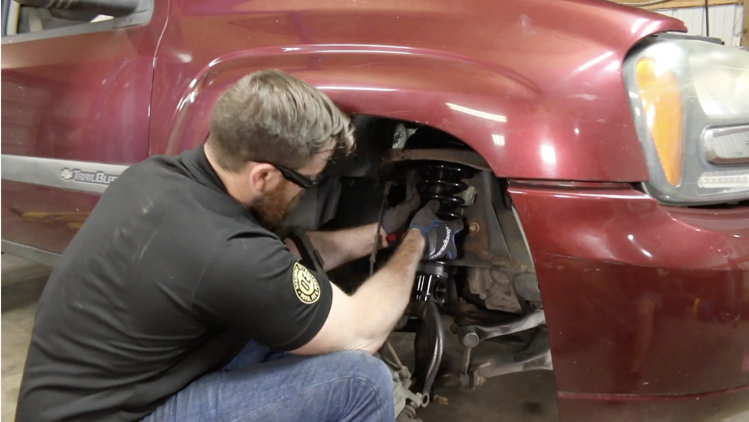 Technician showing how to install a new strut assembly on a Chevy Trailblazer