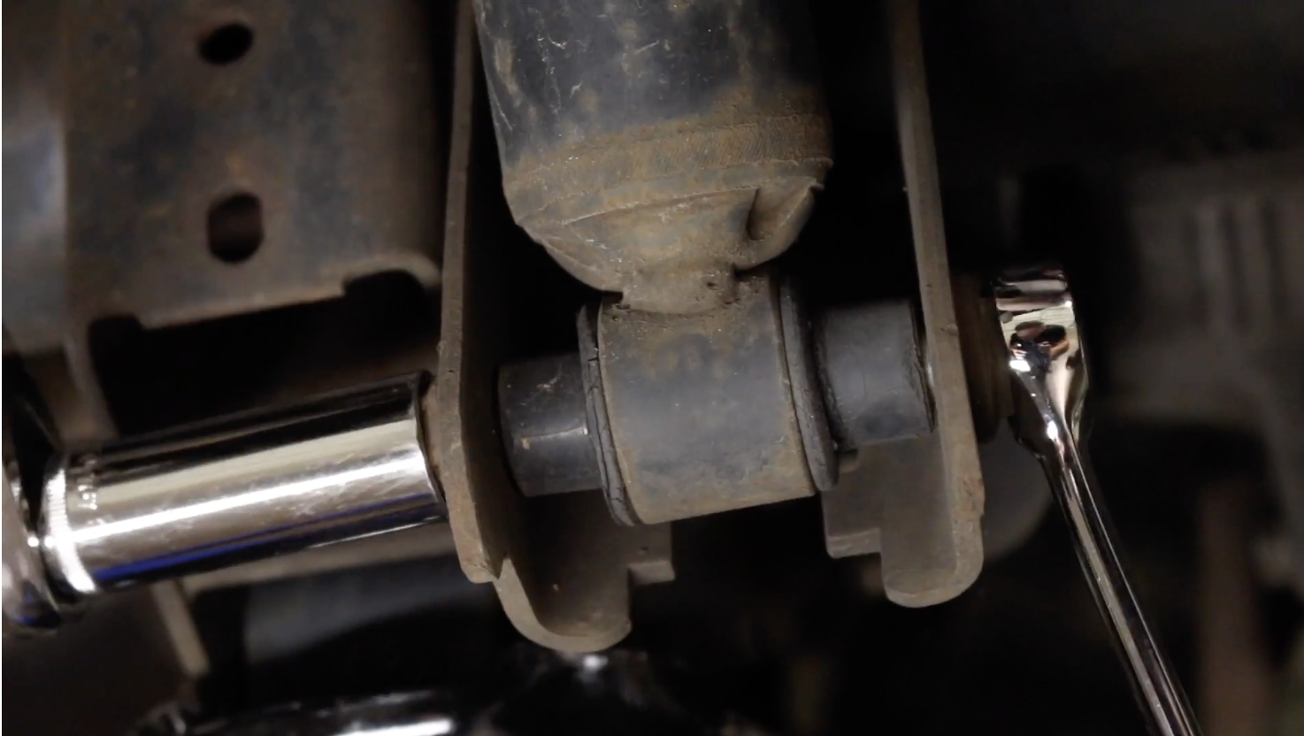 Person removing the lower shock bolt