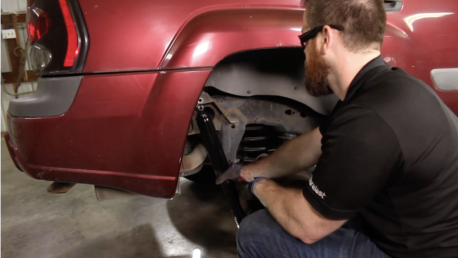 Technician installing new rear shock on a Chevy Trailblazer