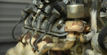 Close up image of an engine with four fuel injectors running along the fuel rail