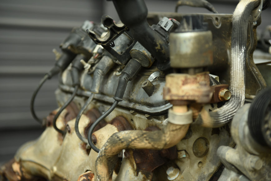 Close up image of an engine with four fuel injectors running along the fuel rail