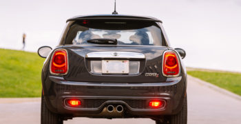 mini cooper coming to a stop on a clear, open road while demonstrating how to bed brakes