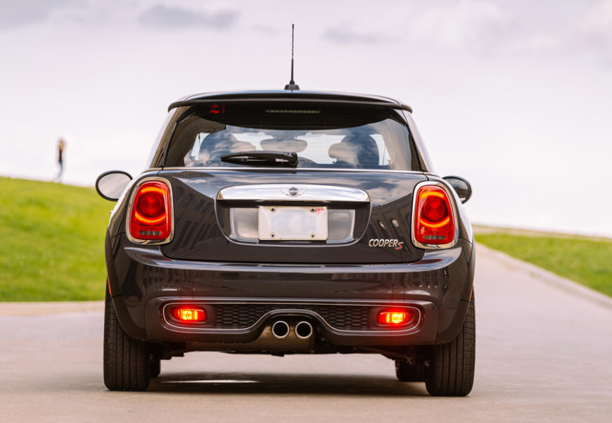 mini cooper coming to a stop on a clear, open road while demonstrating how to bed brakes