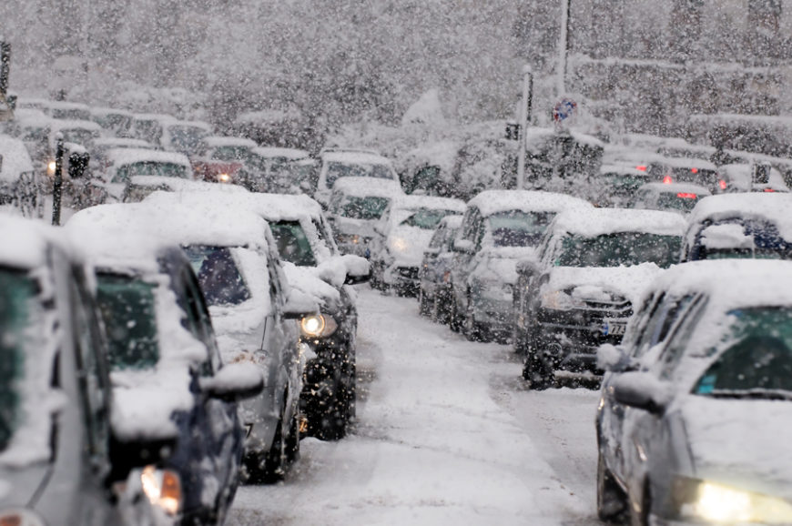 Cars driving through snow and winter road treatments