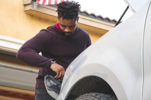 Man removing his headlight housing to get rid of headlight moisture