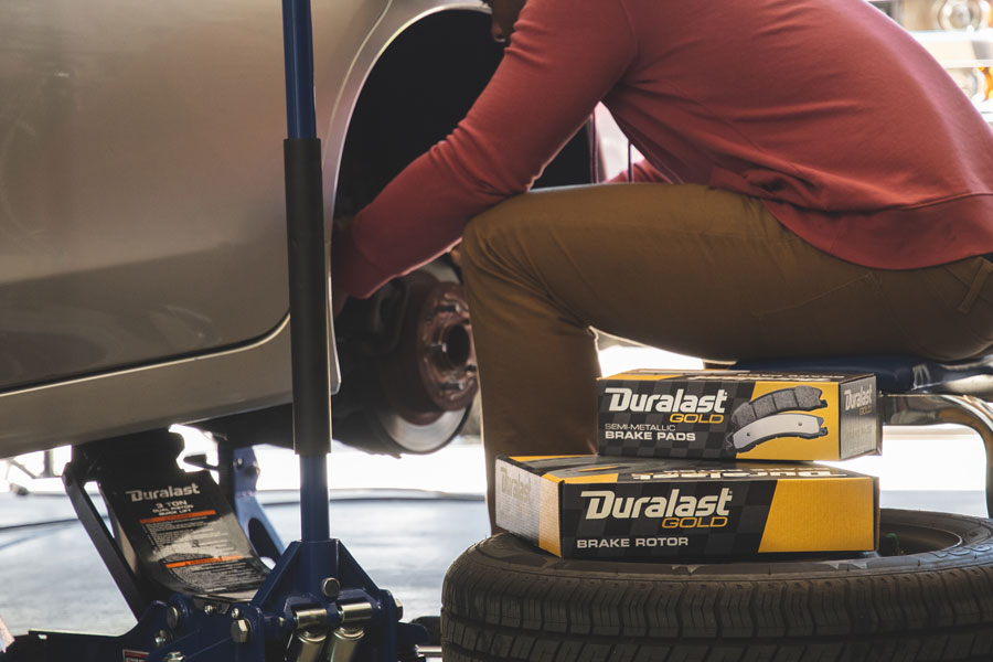 Man changing brakes so he can upgrade to Duralast Gold