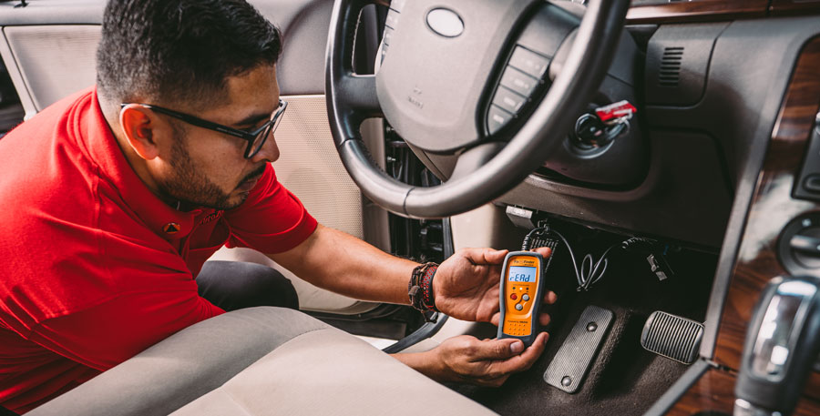 AutoZone associate using code reader to diagnose CEL P0449