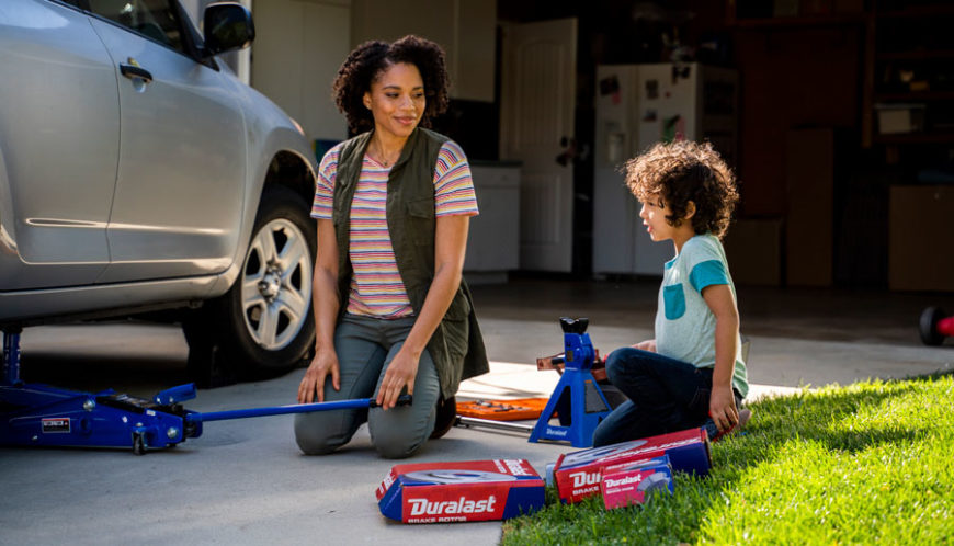 Woman showing her son how to save money on car maintenance in the New Year