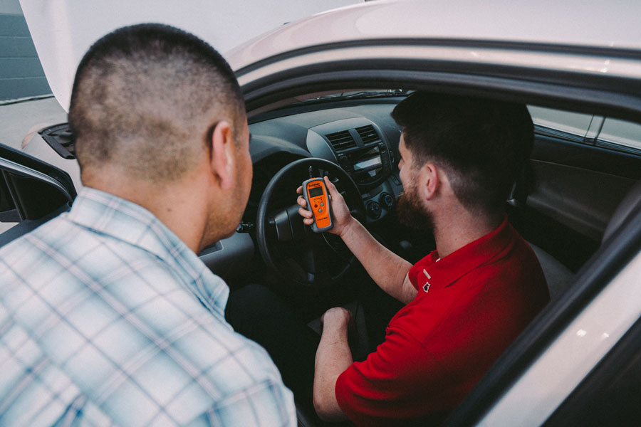 AutoZone associate showing the reading for P1000 to a customer on the Fix Finder scan tool