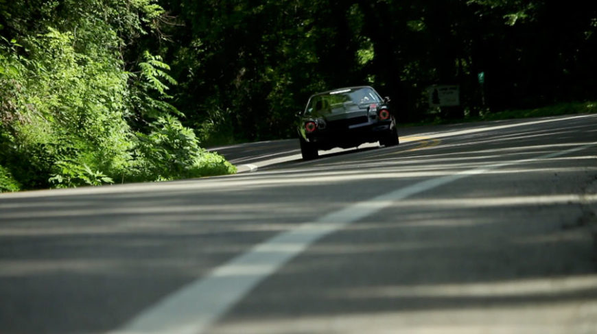 Trans Am cornering quickly around a bend through the trees