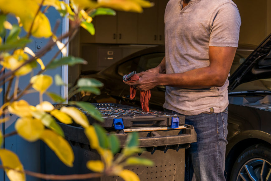 Man cleaning tools while working on his car