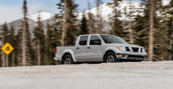 Their travel truck on icy road mountains in background