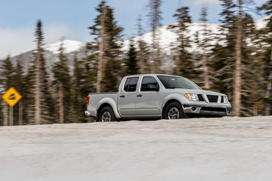 Their travel truck on icy road mountains in background