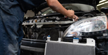 mechanic disasembling vehicle for ac kit install with ac kit in foreground 8 1