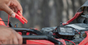 noco genius 2 battery charger being hooked up on atv showing gator clamp