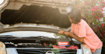 female installing duralast battery ing silver car 1