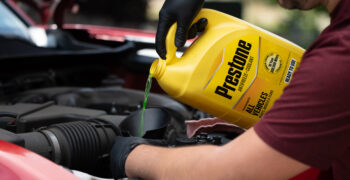 prestone coolant being poured into funel on truck
