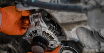 mechanic installing alternator