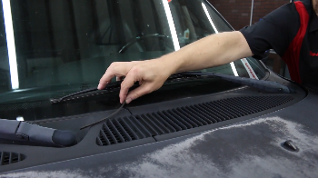 Woman changing the wiper blades on a Jeep.